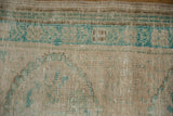 Distressed Oushak pile worn to knot heads in shades of turquoise and cream.