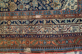 Antique Malayer rug border showing natural dye patterns, exposed foundation, and patch repair.
