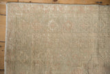 Distressed low-pile texture and secured side cord edge of a vintage Melas rug.