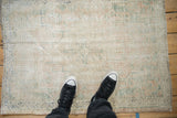 A personal view of the distressed Oushak rug's worn texture and exposed foundation.