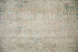 Close-up of the distressed Oushak's low pile showing wear to the knot heads.