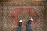 Distressed vintage Oushak rug with faded dusty plum medallion and muted floral field.