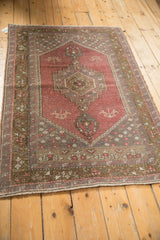 Stepped concentric medallion and germinating plants on a distressed dusty plum Oushak rug.