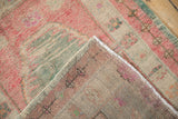 Corner detail of a vintage Oushak rug showing the hand-knotted back and secured side cord.