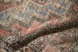 Worn texture of a vintage distressed Oushak rug with muted brick red and dusty aubergine.
