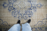 Worn, low-pile texture of a distressed Oushak carpet with visible knot heads and cobalt blue design.