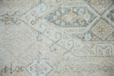 Distressed vintage Sparta carpet: faded ivory, beige, and dusty denim blue pattern with wear.