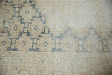 Distressed texture and faded denim blue geometric motifs on a vintage Sparta rug.