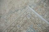 Vintage Distressed Sparta rug corner, showing worn geometric patterns in ivory, beige, dusty blue, and fringe.