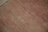 Abrashed dusty rose pile of a vintage Oushak rug, showing pale, woven backwards numbers.