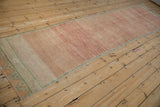 Distressed Oushak runner field with heavy abrash, pale ruby, rose, and tangerine tones.