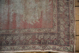 Distressed Oushak runner border with pale aubergine germinating plant motif and worn texture.