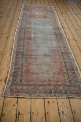 Hand knotted Oushak runner with germinating plant border and distressed dusty rose pile.