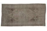 Vintage distressed Oushak rug with a geometric medallion in muted, tone-on-tone greige, silver, and dusty green.