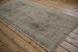 Full length view of a distressed Oushak rug showing its even wear and tone-on-tone silver-grey pattern.
