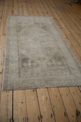 Angled perspective of a distressed Oushak rug highlighting its soft greige and silver patina.