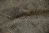 Close-up on the even wear of the distressed Oushak rug, showing low pile and faint foundation.