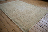 Faded sea foam green and pale coffee brown border of a distressed Oushak rug.
