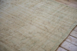 Distressed Vintage Oushak carpet with worn pile, showing faded cream, ivory, and pale green tones.