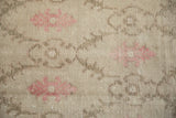 Even wear across the knot heads of a vintage Oushak showing dusty mauve floral palmettes.