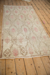 Angled view of a distressed Oushak runner showing its even wear and repeating floral palmettes.