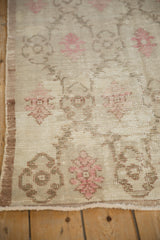 Worn knot heads and faint foundation visible on a distressed Oushak rug with pink floral details.