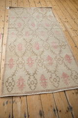 Corner of a distressed Oushak runner showing its secured side cord and time-softened floral pattern.