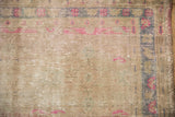 Distressed Oushak rug surface showing knot heads, fuchsia blossoms, and oxidized silver tones.