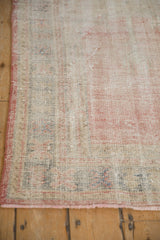 Distressed Oushak rug detail: worn pile revealing foundation, faded ivory, pink, and blue.