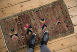 Distressed Oushak rug with abrashed brown ground, vivid fuchsia and blue geometric starbursts.