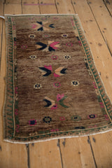 Distressed Oushak rug close-up: polychromatic pinwheel starbursts on abrashed ground, wave border.