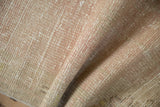 Textured pile of distressed vintage Oushak rug, showing wear and muted rose, beige, ivory.