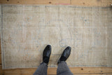 Worn cream pile and faded blue floral motifs on a distressed Oushak runner.