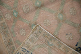 Distressed Oushak runner, dusty rose and green pile showing wear, visible foundation, and woven back.