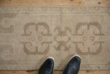 Distressed Oushak runner with central inverted medallion, showing soft ivory and beige tones.