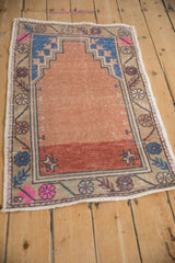 Distressed vintage Oushak runner corner with blue prayer motif, starburst pinwheels, and faded floral border.