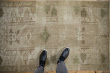 Distressed vintage Melas rug showing geometric guls, heavy abrashes, and beige ivory tones.
