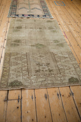 Distressed vintage Turkish Melas rug corner, displaying geometric motifs, olive green abrashes, and side selvages.