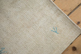 Powder blue addendum accent on the textured, distressed ivory field of a vintage Oushak rug.