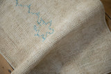 Folded view showing the textured, hand-knotted foundation of a vintage Oushak rug.