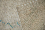 Close-up of the hand-knotted wool foundation and ribbed ivory pile of a vintage Oushak rug.