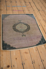 Textured mauve abrashed ground with dark teal stepped spandrel and roundel motif.
