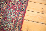 Intricate curvilinear motifs on a vintage Persian Isfahan rug, featuring deep red and blue.