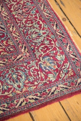 Intricate deep purple Isfahan rug corner with blue and ivory curvilinear floral design, overcast edge.
