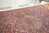 Finely knotted pile of an Isfahan rug, showing intricate ruby and deep indigo floral patterns.