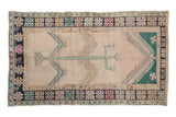 Vintage distressed Oushak rug with a geometric tree of life motif in dusty teal and blue on an even-worn ivory field.