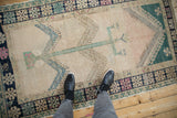 Full view of a distressed Oushak rug with a central tree of life motif and soft, low-pile texture.