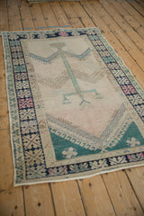 Vintage distressed Oushak rug from an angle, showing the full tree of life design.