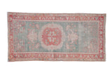 Distressed vintage Oushak rug with cherry red medallion, seafoam green field, and ivory floral motifs.