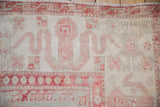 Expressive cloudband and blossom motifs in cherry red on a vintage distressed Oushak rug.